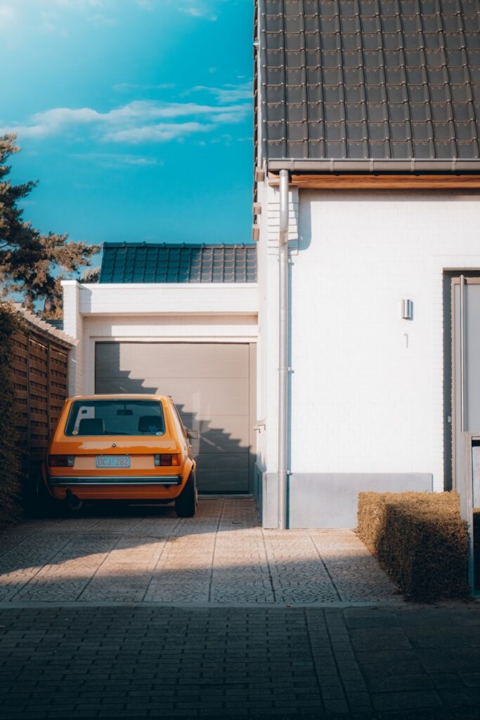 yellow car parked beside white building