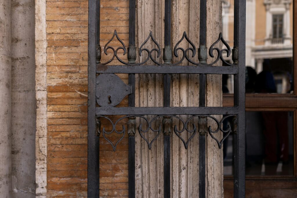 a metal gate with a skull on it in front of a brick building