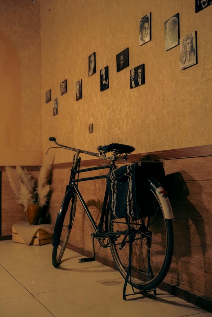 a bicycle parked against a wall with pictures on the wall